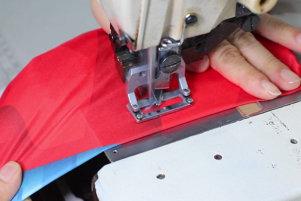 Sewing a custom sublimated jersey panel on an industrial machine at Glory Ground