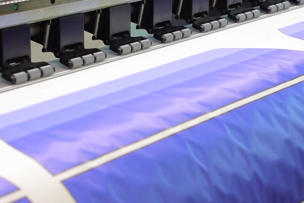 Close-up of a sublimation printer printing jersey designs onto transfer paper