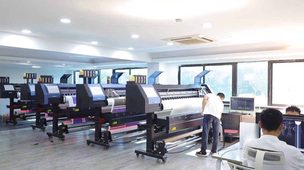 Row of large-format sublimation printers in the Glory Ground printing workshop