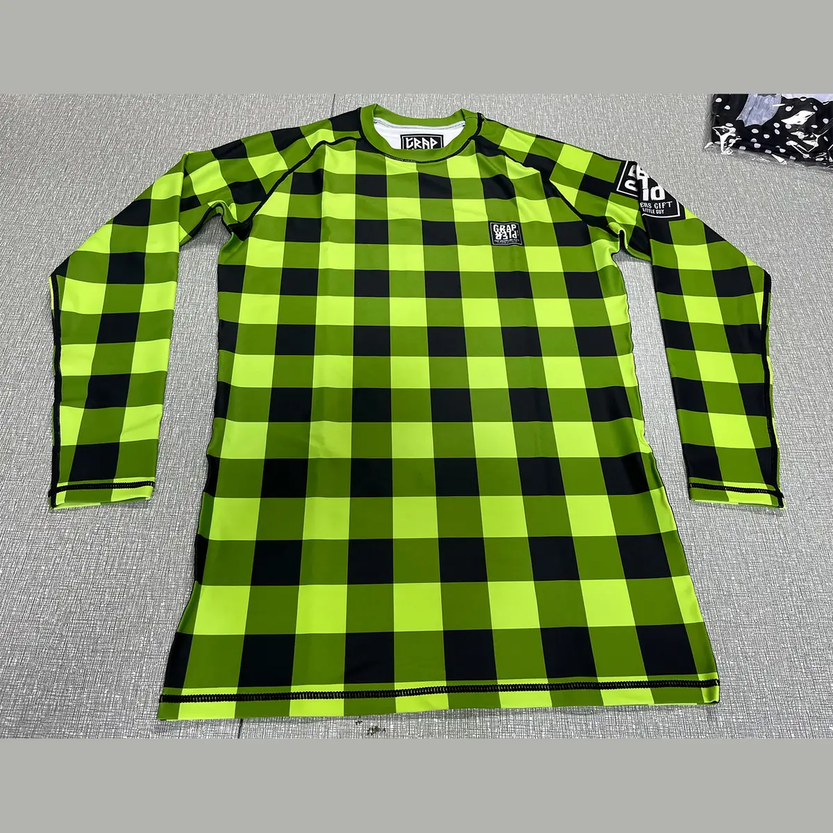 Custom long sleeve sublimated rash guard in green, purple and blue check pattern