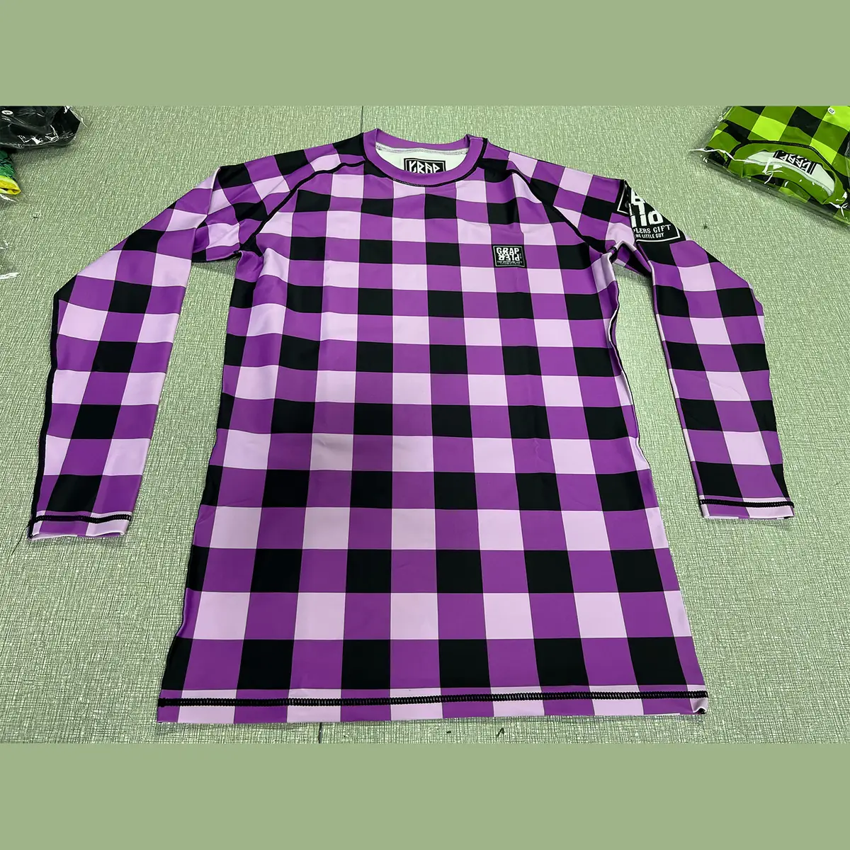 Custom long sleeve sublimated rash guard in green, purple and blue check pattern